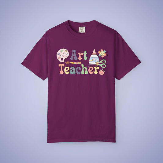 Maroon t shirt with 'Art Teacher' text and graphics on a boysenberry purple background