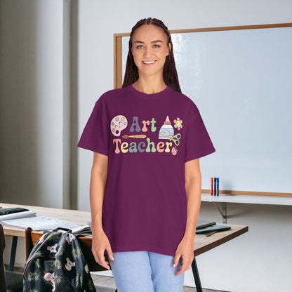 Person wearing a purple 'Art Teacher' t-shirt in an art classroom setting.